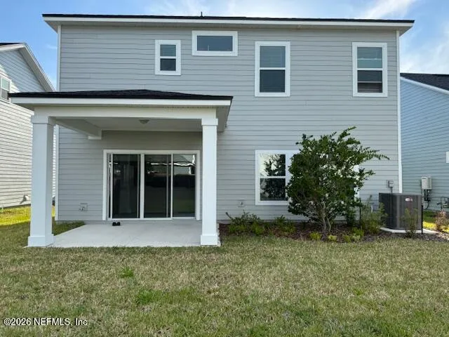 a front view of a house with a yard and potted plants