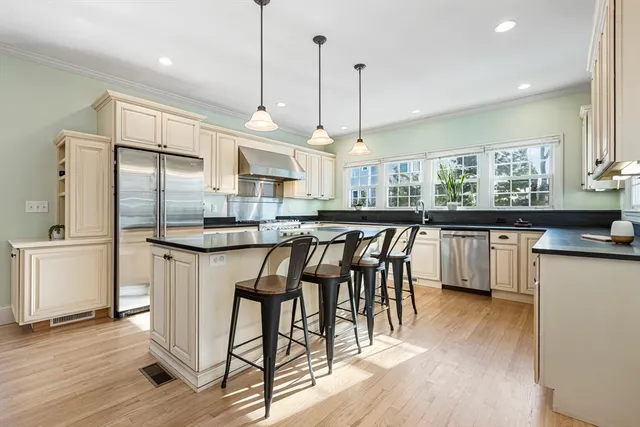 a kitchen with stainless steel appliances granite countertop wooden floor window and cabinets