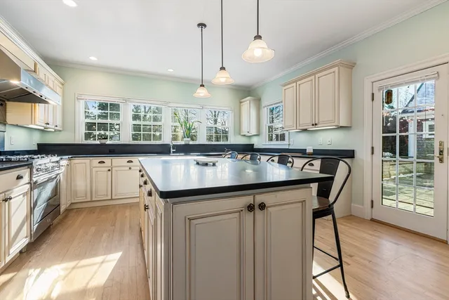 a kitchen with stainless steel appliances granite countertop a sink a stove and a wooden floors