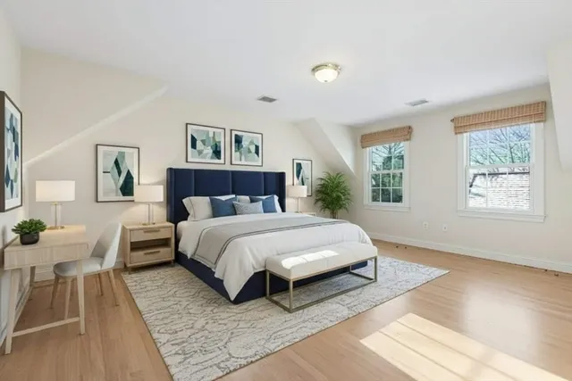 a spacious bedroom with a bed and wooden floor