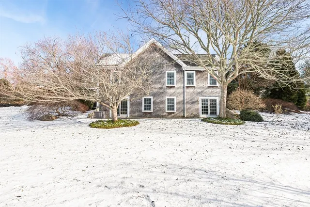 a front view of a house with a yard covered in snow