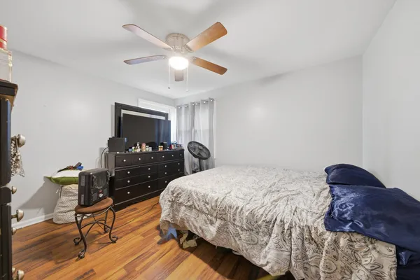 a bedroom with a bed and wooden floor