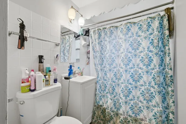a white bath tub sitting next to a white toilet and sink a window