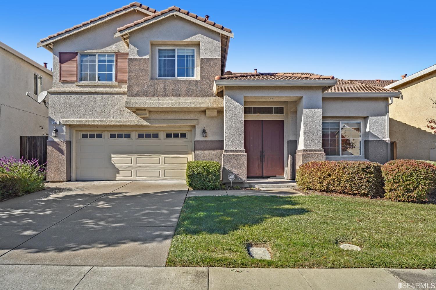 a front view of a house with a yard and garage