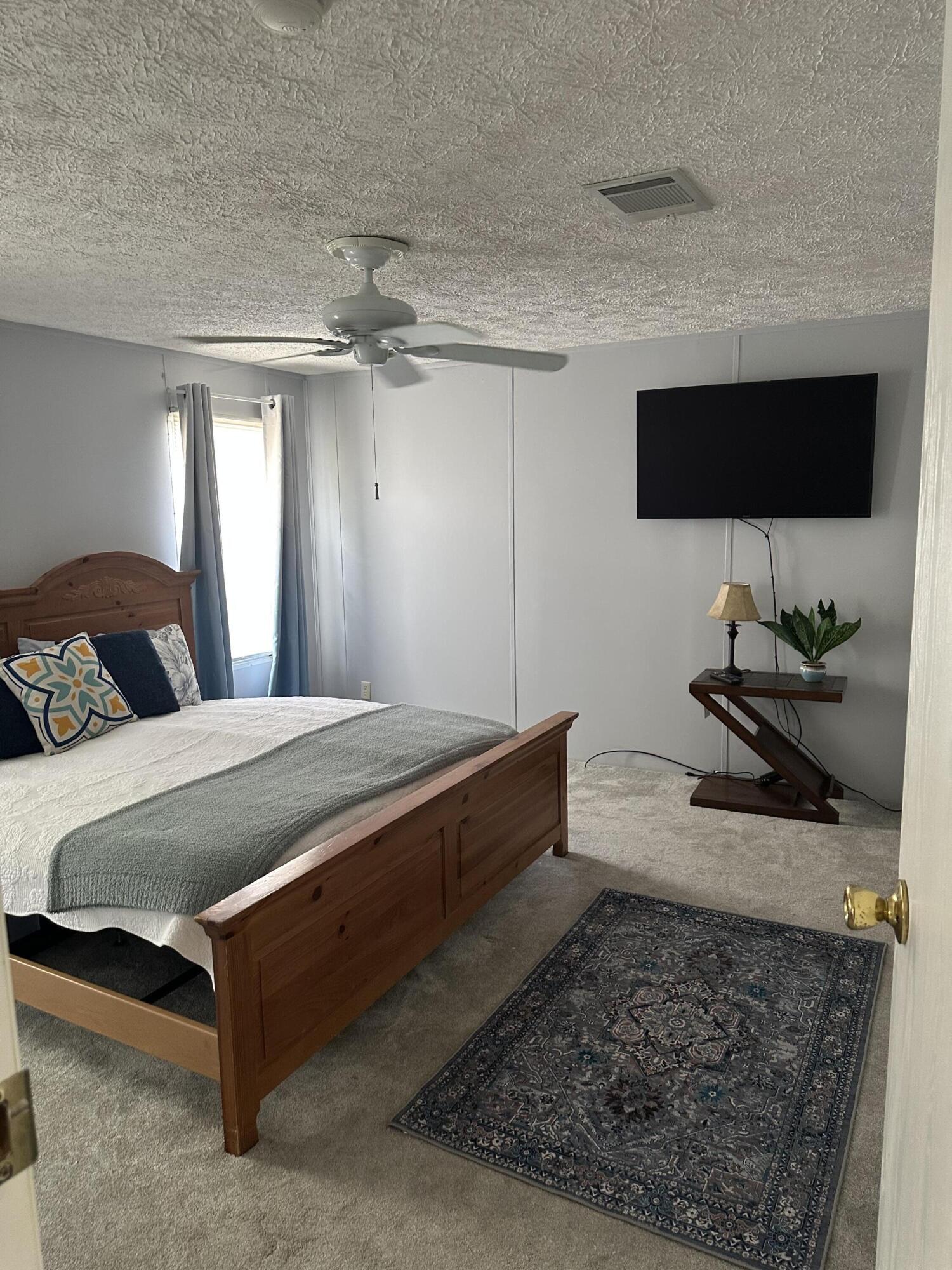 1510 Southwest 35th Circle Okeechobee, FL 34974 - Photo 16 of 53 a spacious bedroom with a bed and flat screen tv