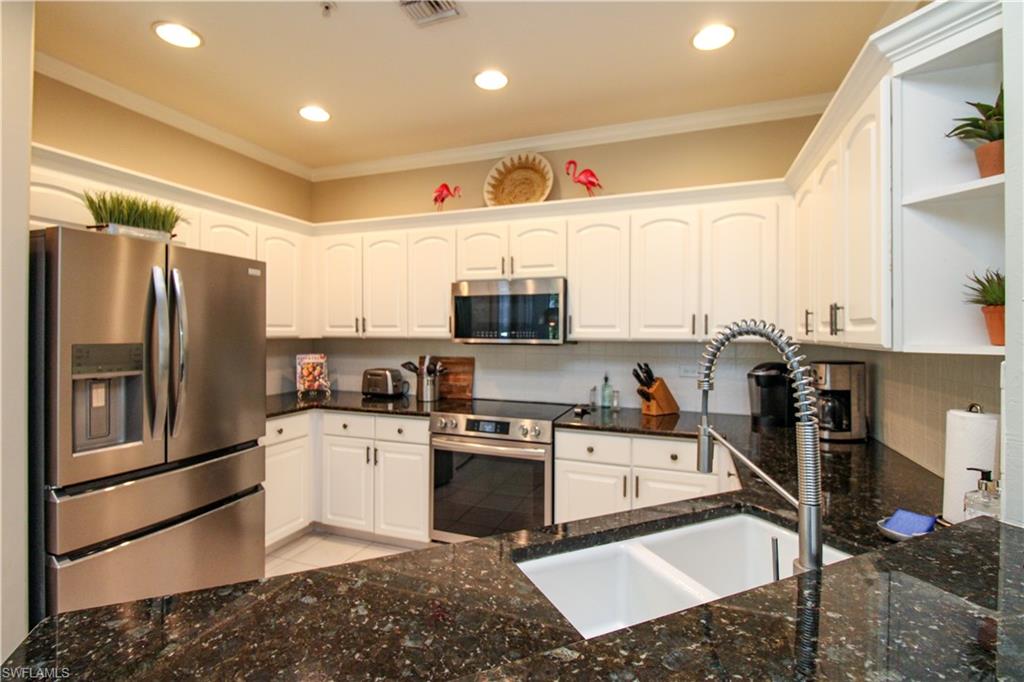 8488 Radcliffe Terrace, Unit 104 Naples, FL 34120 - Photo 14 of 50 a kitchen with stainless steel appliances granite countertop a refrigerator sink and stove
