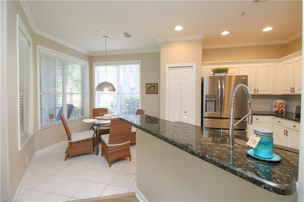 8488 Radcliffe Terrace, Unit 104 Naples, FL 34120 - Photo 20 of 50 a room with granite countertop kitchen island stainless steel appliances a sink and a counter top space
