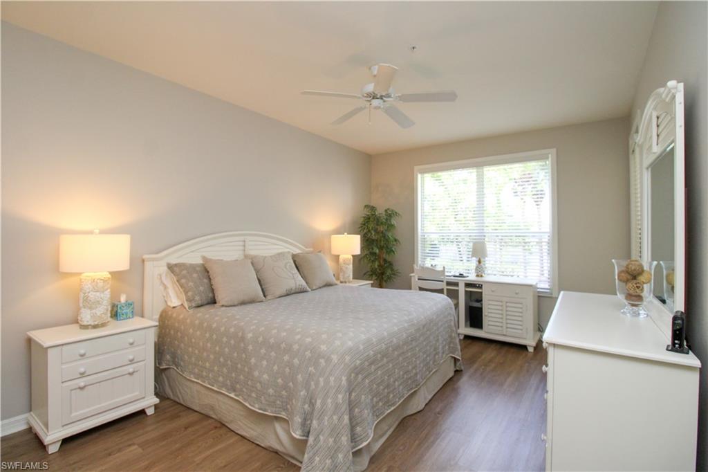 8488 Radcliffe Terrace, Unit 104 Naples, FL 34120 - Photo 22 of 50 a bedroom with a bed and a chandelier
