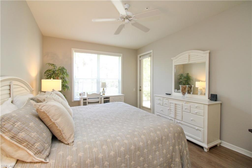 8488 Radcliffe Terrace, Unit 104 Naples, FL 34120 - Photo 25 of 50 a bedroom with a large bed and a chandelier fan