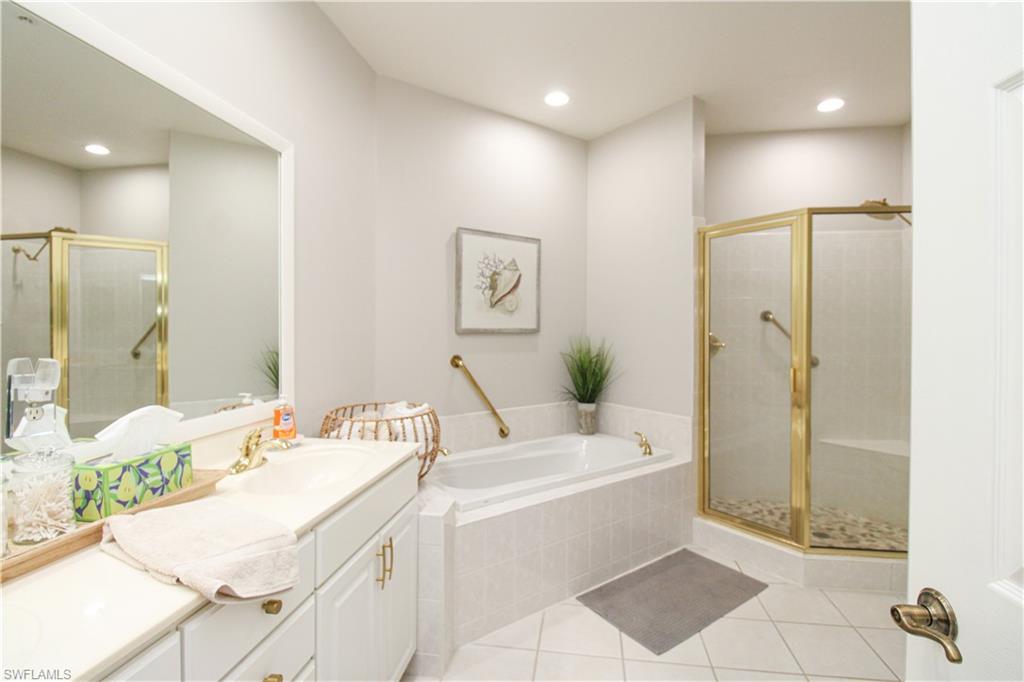 8488 Radcliffe Terrace, Unit 104 Naples, FL 34120 - Photo 28 of 50 a spacious bathroom with a double vanity sink mirror and shower