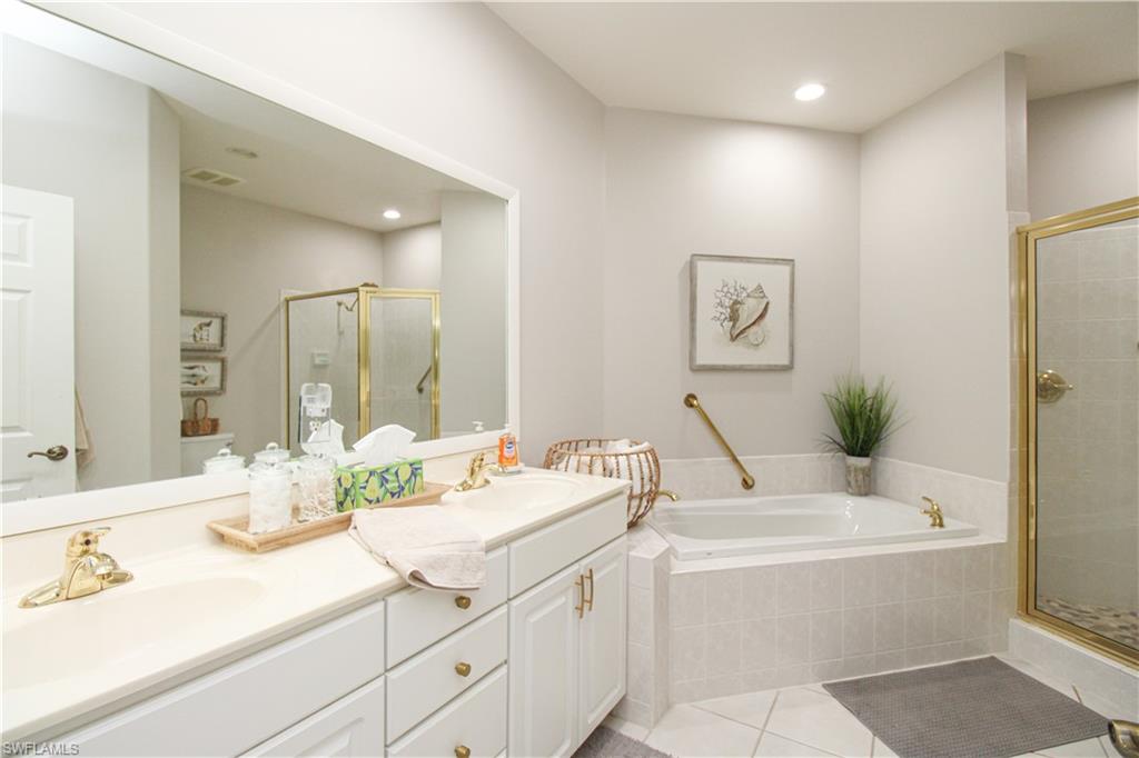 8488 Radcliffe Terrace, Unit 104 Naples, FL 34120 - Photo 29 of 50 a bathroom with a tub sink and mirror