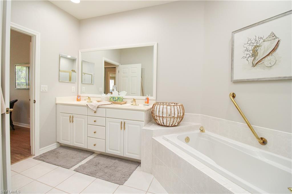 8488 Radcliffe Terrace, Unit 104 Naples, FL 34120 - Photo 31 of 50 a bathroom with a tub sink and mirror