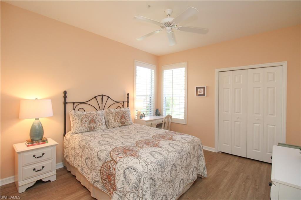 8488 Radcliffe Terrace, Unit 104 Naples, FL 34120 - Photo 32 of 50 a bedroom with a large bed and a chandelier