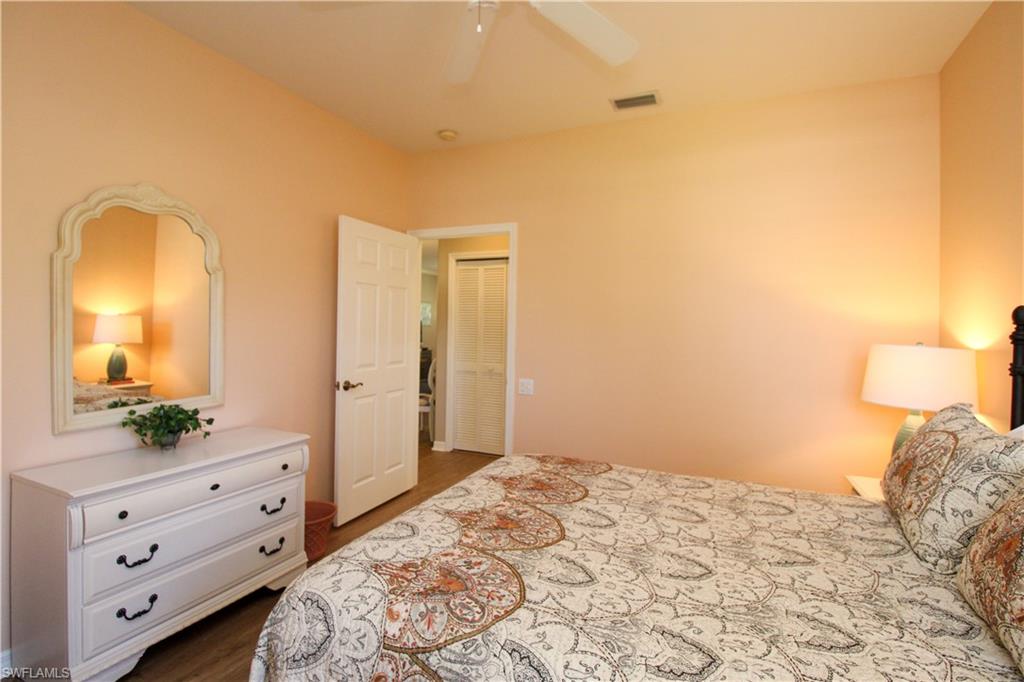 8488 Radcliffe Terrace, Unit 104 Naples, FL 34120 - Photo 35 of 50 a bedroom with a bed and a dresser in it