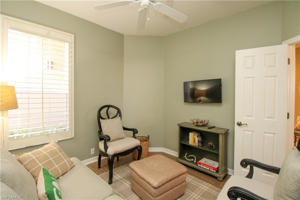 8488 Radcliffe Terrace, Unit 104 Naples, FL 34120 - Photo 39 of 50 a living room with furniture a flat screen tv and a fireplace