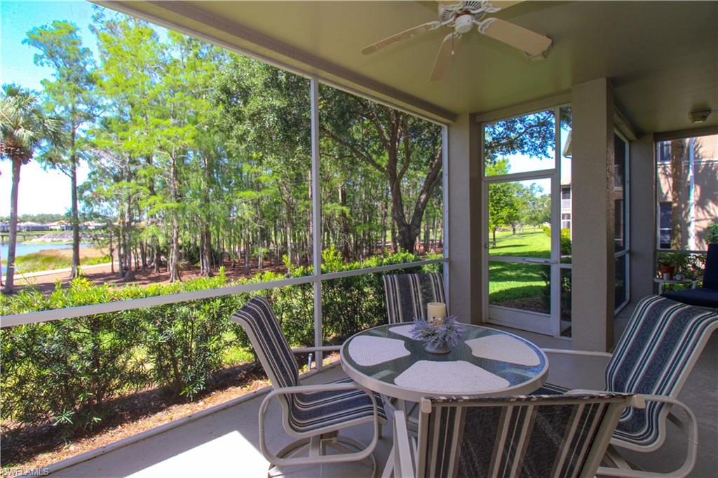 8488 Radcliffe Terrace, Unit 104 Naples, FL 34120 - Photo 42 of 50 a view of a patio with a table chairs and a floor to ceiling window