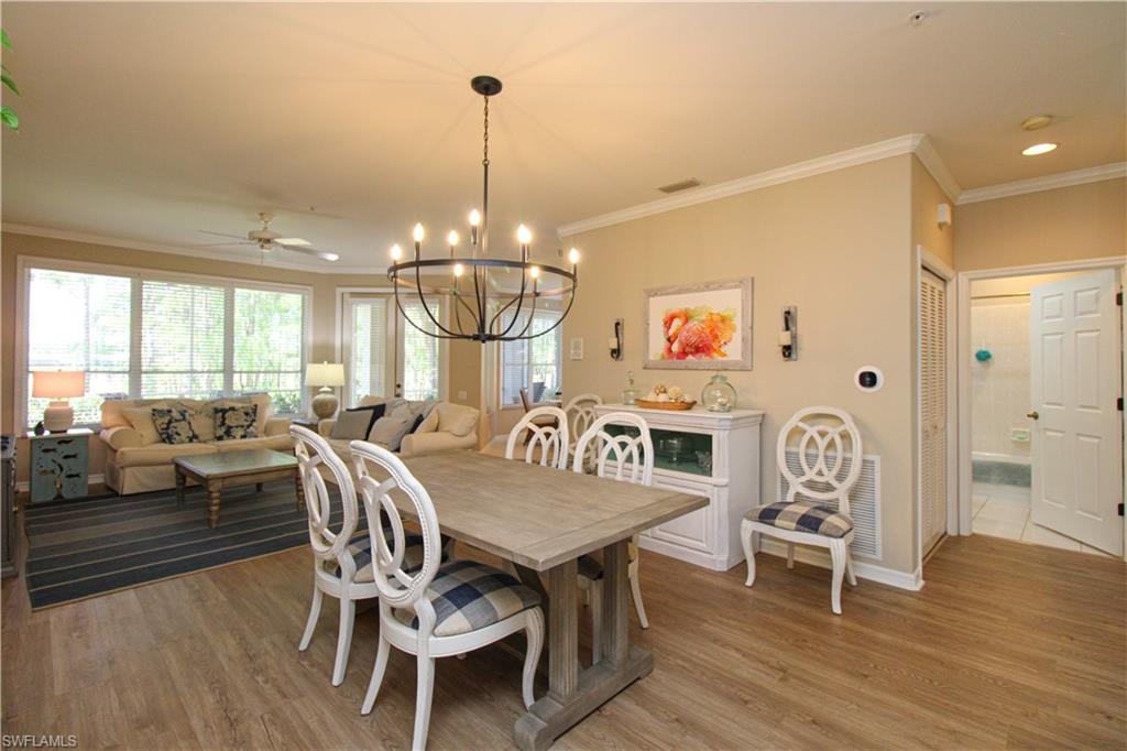 8488 Radcliffe Terrace, Unit 104 Naples, FL 34120 - Photo 7 of 50 a view of a dining room and livingroom with furniture wooden floor a chandelier