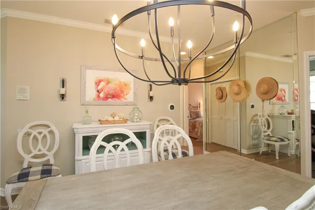 a dining room with furniture a chandelier and wooden floor