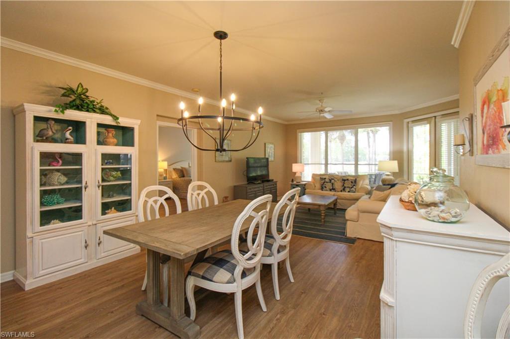 8488 Radcliffe Terrace, Unit 104 Naples, FL 34120 - Photo 10 of 50 a dining room with furniture a chandelier and wooden floor