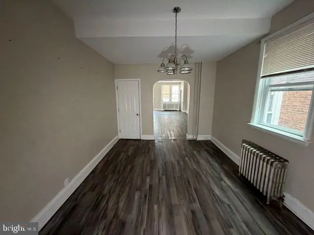 a view of empty room with wooden floor and window