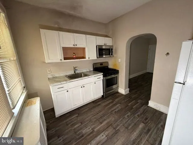 a kitchen with stainless steel appliances a refrigerator sink and microwave