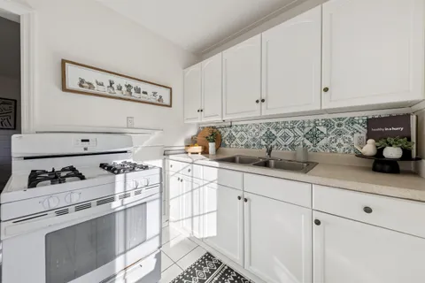 a kitchen with white cabinets and white appliances