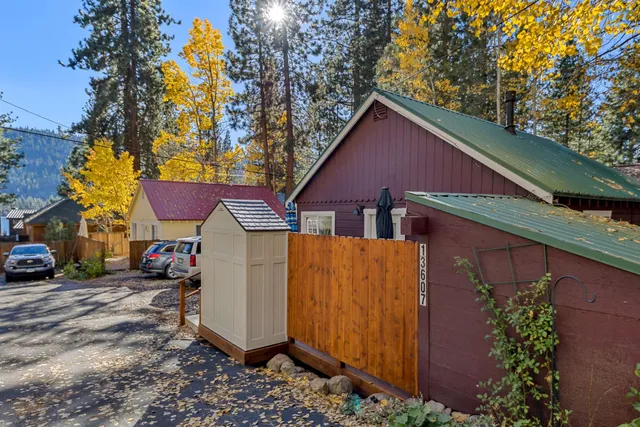 a view of a house with a yard plants and a car parked in front of it