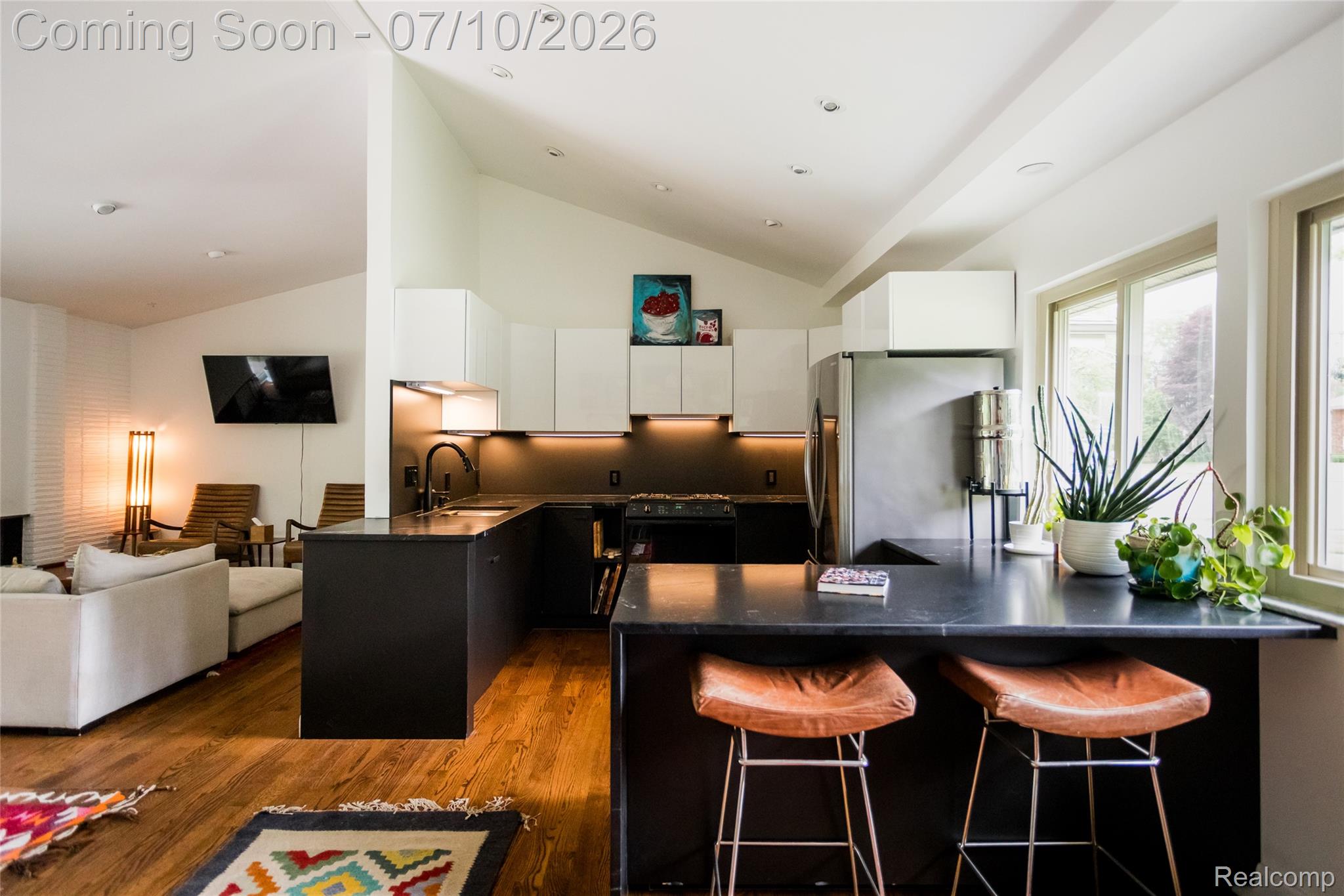 600 Middlesex Road Grosse Pointe, MI 48230 - Photo 13 of 43 Modern kitchen featuring a black countertop island with seating, dark lower cabinetry, and white upper cabinetry