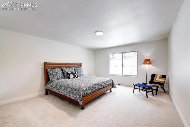 a bedroom with a bed and a lamp on the dresser