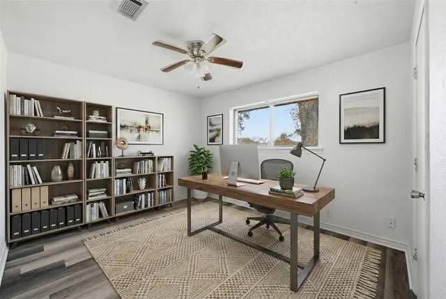 a workspace with wooden floor and a bookshelf