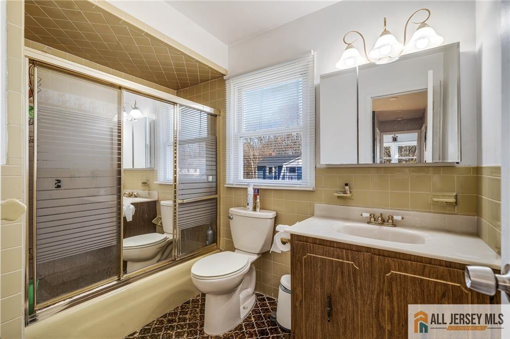 62 Laura Avenue Edison, NJ 08820 - Photo 27 of 35 a bathroom with a sink a toilet and a large mirror