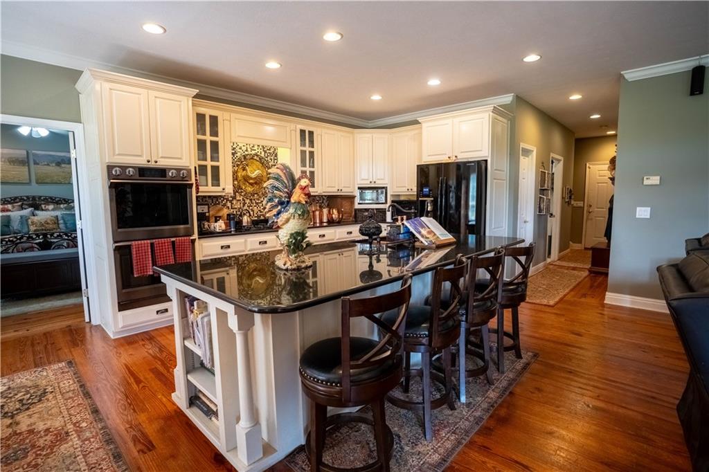 442 Buffalo Creek Road Carrollton, GA 30117 - Photo 15 of 39 a kitchen with stainless steel appliances granite countertop a table chairs and a refrigerator