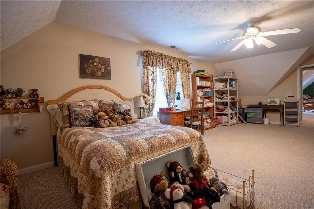 442 Buffalo Creek Road Carrollton, GA 30117 - Photo 26 of 39 a bedroom with a bed and a chandelier