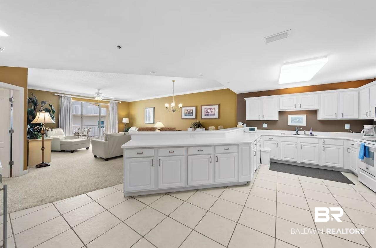 27770 Canal Road, Unit 2502 Orange Beach, AL 36561 - Photo 10 of 55 Kitchen featuring decorative light fixtures, white cabinets, a chandelier, light countertops, and light tile patterned floors