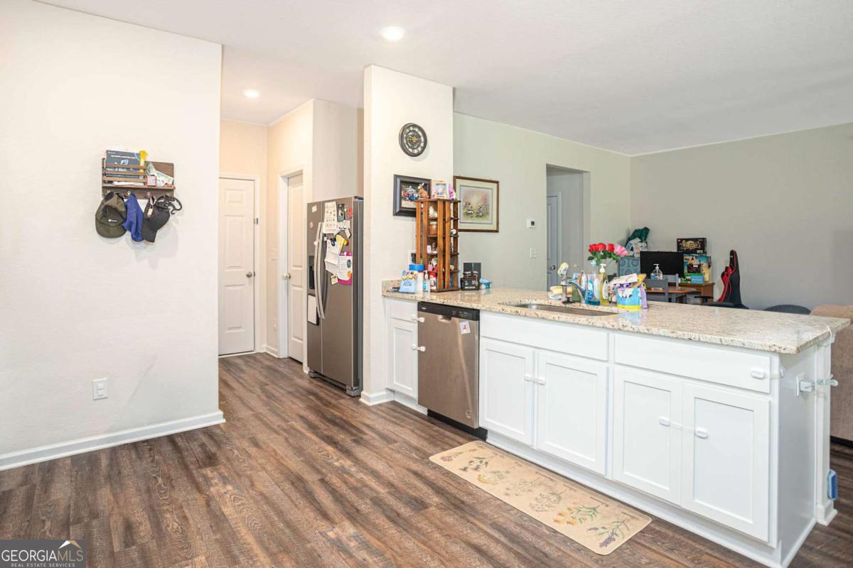 653 Meadows Farm Way Monroe, GA 30655 - Photo 14 of 34 a kitchen with cabinets and wooden floor