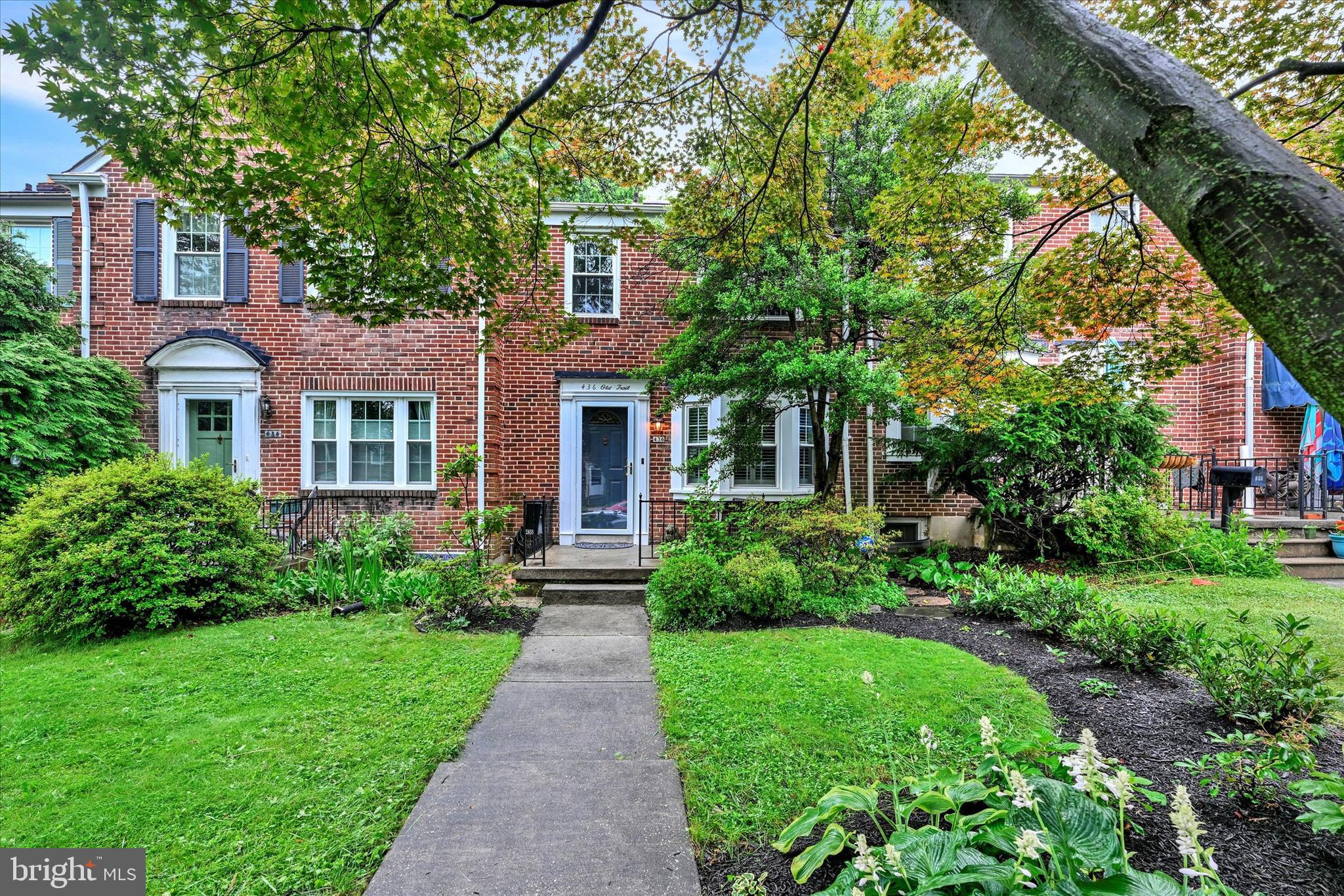 a front view of a house with a yard and potted plants