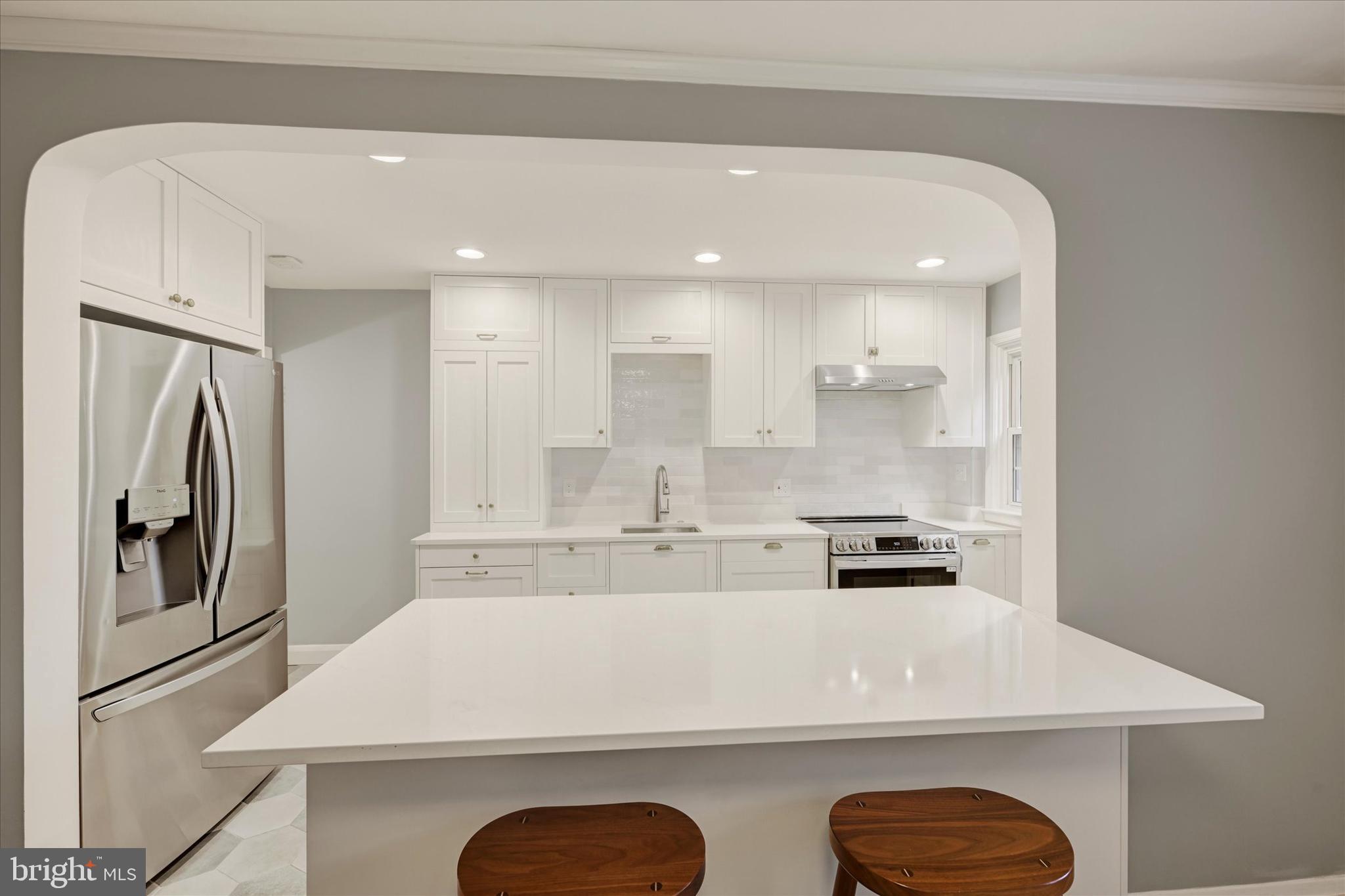 436 Old Trail Baltimore, MD 21212 - Photo 8 of 32 a kitchen with stainless steel appliances granite countertop a refrigerator a stove and a sink with wooden floor