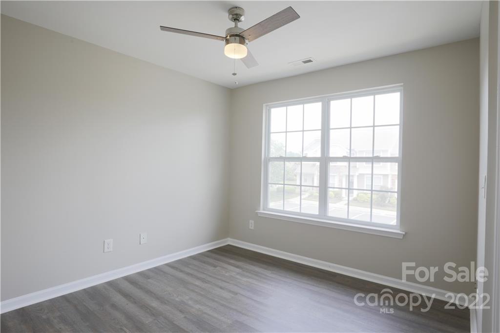 114 Chimney Rock Lane Fort Mill, SC 29708 - Photo 7 of 12 an empty room with wooden floor ceiling fan and windows