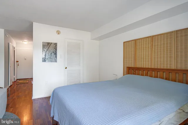 a bedroom with a bed and a painting on the wall