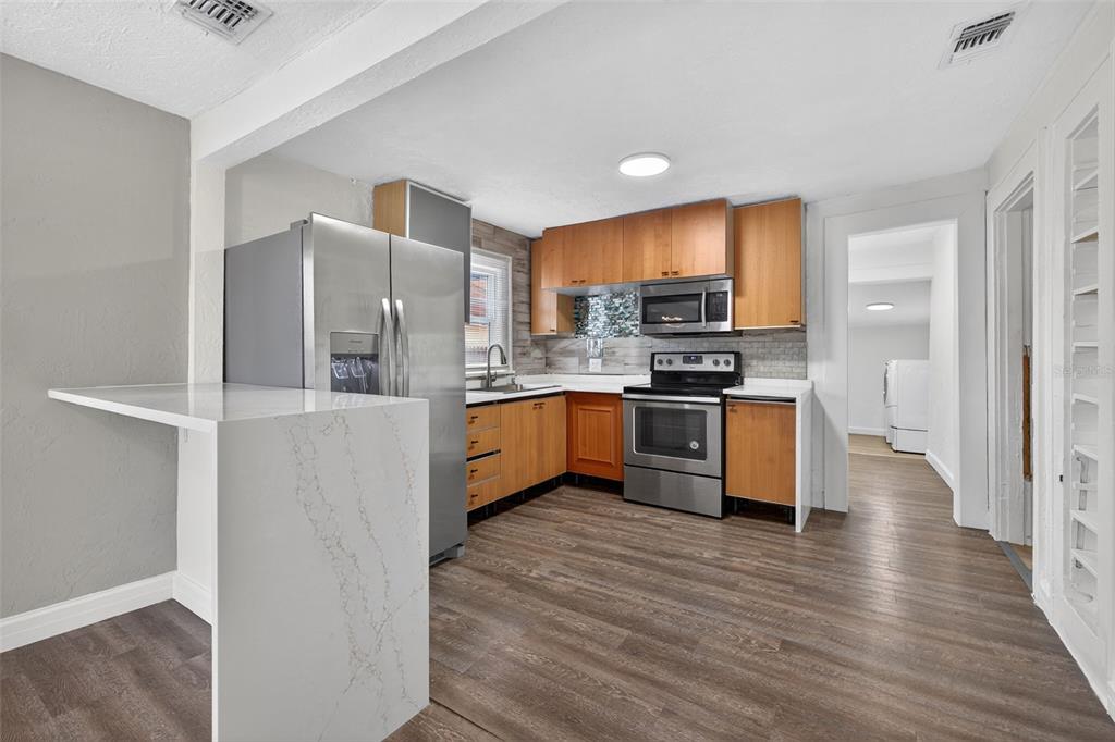 2725 14th Avenue South St. Petersburg, FL 33712 - Photo 6 of 41 a kitchen with stainless steel appliances a refrigerator and a stove top oven