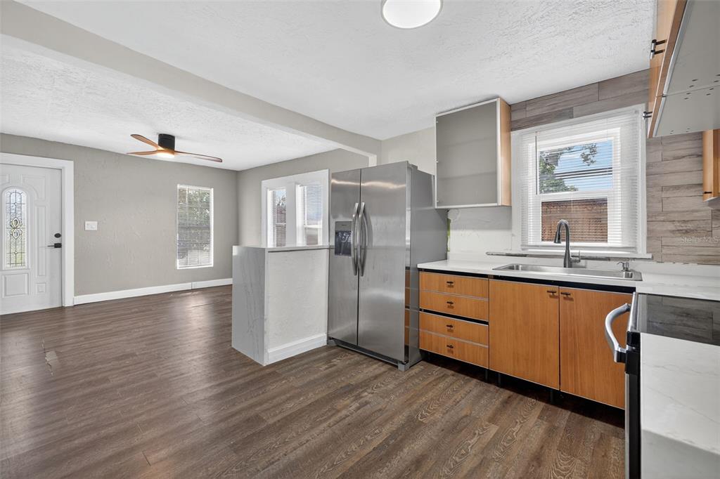 2725 14th Avenue South St. Petersburg, FL 33712 - Photo 9 of 41 a kitchen with stainless steel appliances granite countertop a refrigerator a sink dishwasher a stove with wooden cabinets and floors