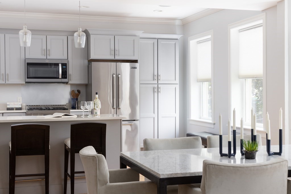 177 Winthrop Road, Unit 3 Brookline, MA 02445 - Photo 12 of 22 a kitchen with stainless steel appliances granite countertop a stove a refrigerator a white table and chairs