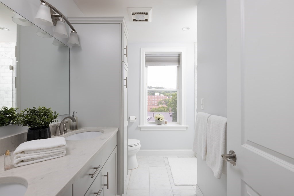 177 Winthrop Road, Unit 3 Brookline, MA 02445 - Photo 8 of 22 a bathroom with a granite countertop sink a mirror a vanity and a shower