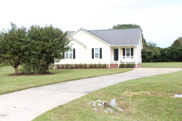 a front view of a house with a yard and trees
