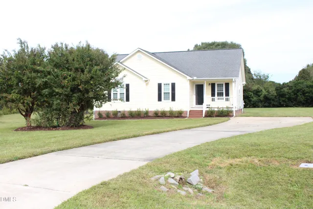 a front view of a house with a yard and trees