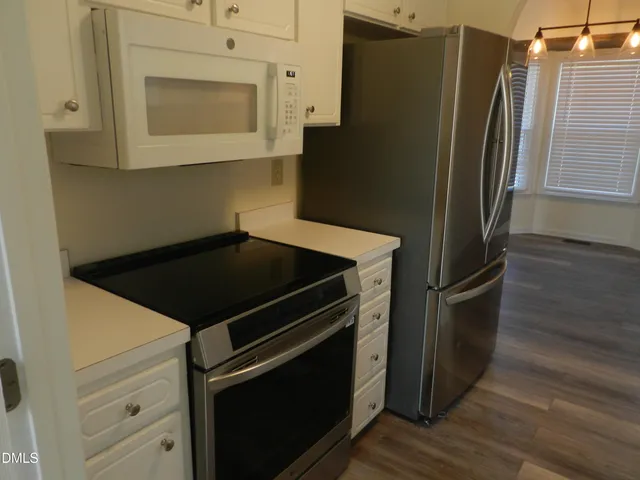 a close view of a refrigerator and a microwave in a kitchen