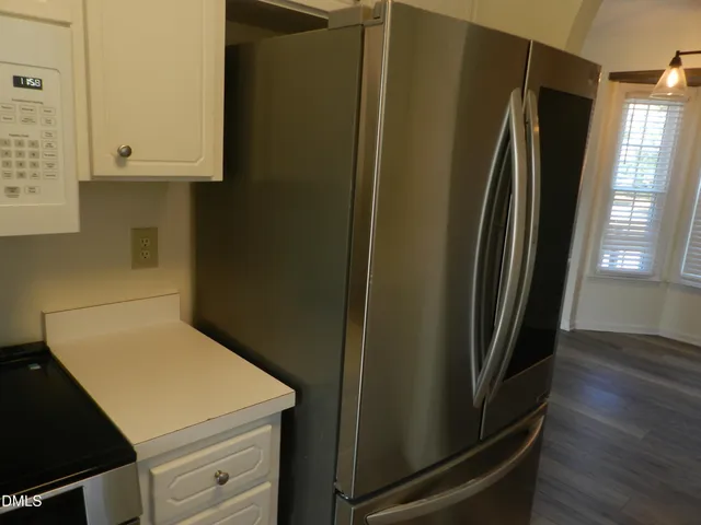 a kitchen with metallic refrigerator and window