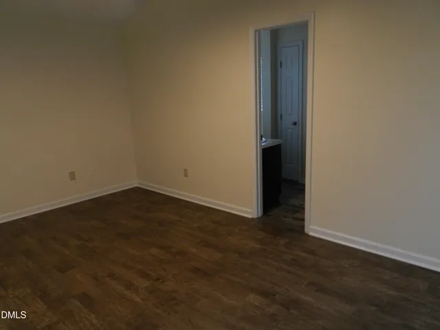 an empty room with wooden floor and closet