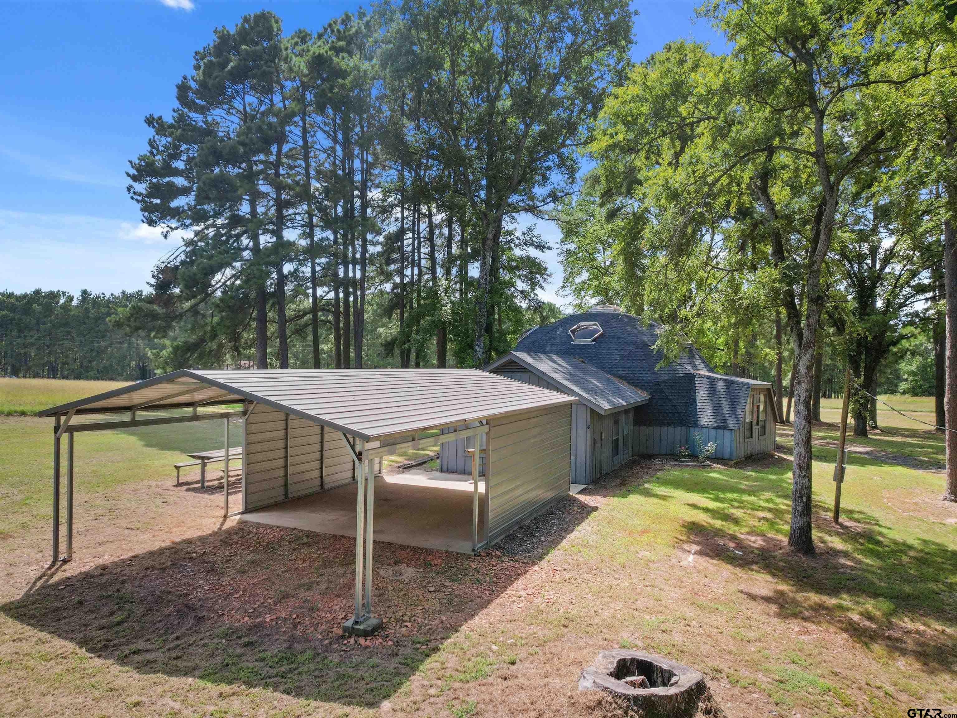 a view of a backyard with table and chairs under an umbrella