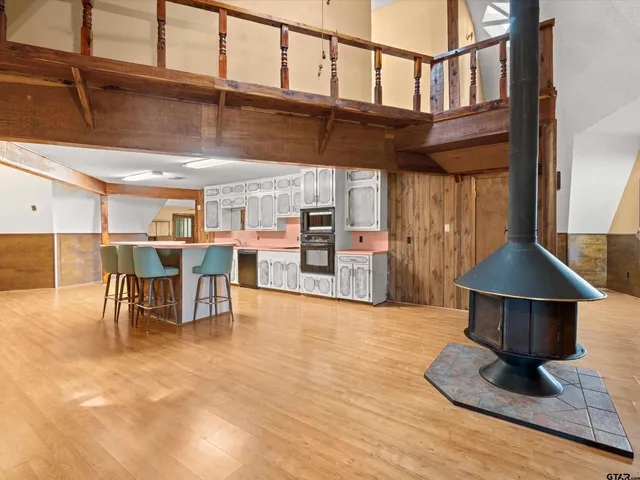 a kitchen with stainless steel appliances a dining table chairs microwave and sink